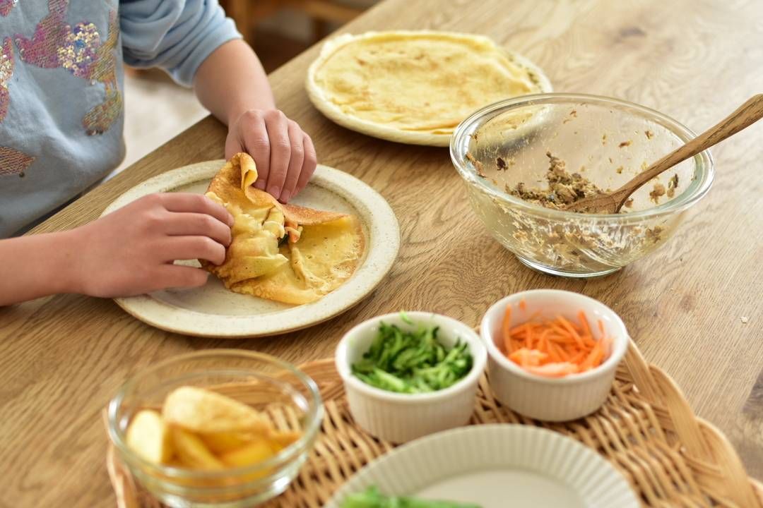 テーブルで彩り野菜とサバのフライズ・ラップを作っている様子