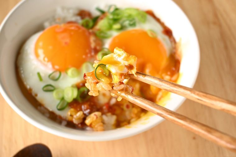 目玉焼き丼を箸ですくう様子