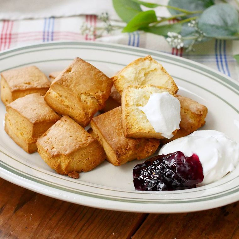 緑色の縁取りの白色の楕円の皿に盛られた四角のプレーンスコーン