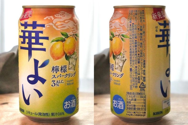 木のカッティングボードにのったレモンの黄色い缶チューハイの成分表示とグレーの布