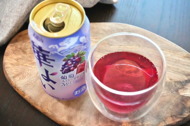 木のカッティングボードにのった葡萄の紫色の缶チューハイとグラス