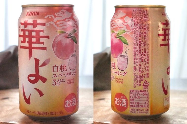 木のカッティングボードにのった白桃のピンク色の缶チューハイの成分表示とグレーの布