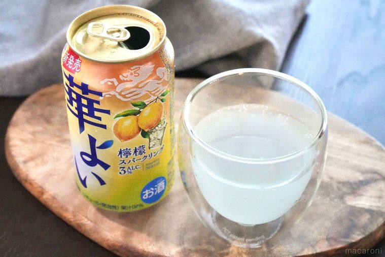 木のカッティングボードにのったレモンの黄色い缶チューハイとグラスとグレーの布