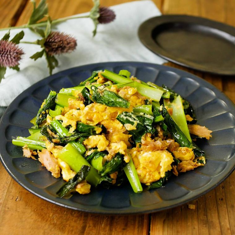 黒い皿に盛られた小松菜とツナの卵炒め