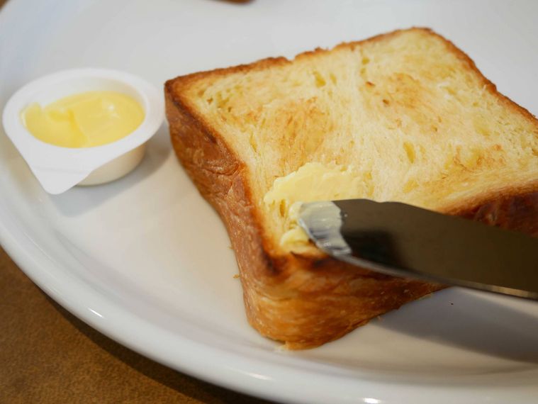 デニッシュトーストにバターを塗っている様子