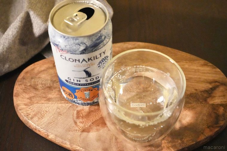 木のカッティングボードにのったアイリッシュジンソーダの缶と注いだグラスとグレーの布
