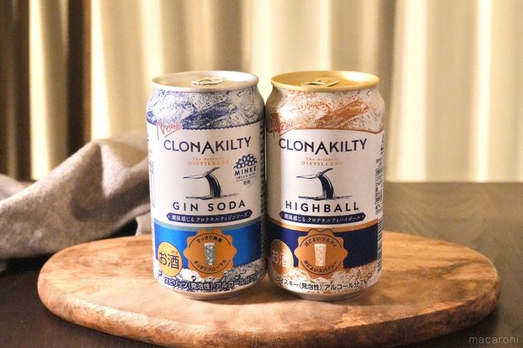 木のカッティングボードにのったアイリッシュジンとウイスキーのハイボールとソーダの缶とグレーの布