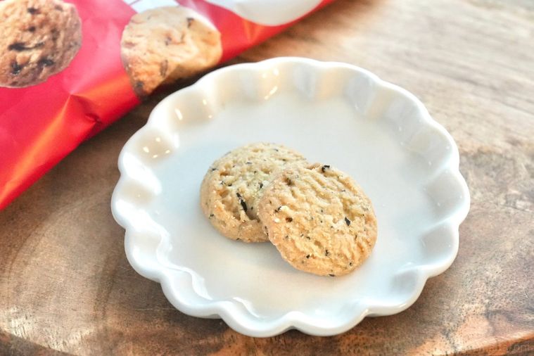 白いテーブルクロスとストライプの布と木のカッティングボードと白い小皿にのったギルトフリーのサブレ