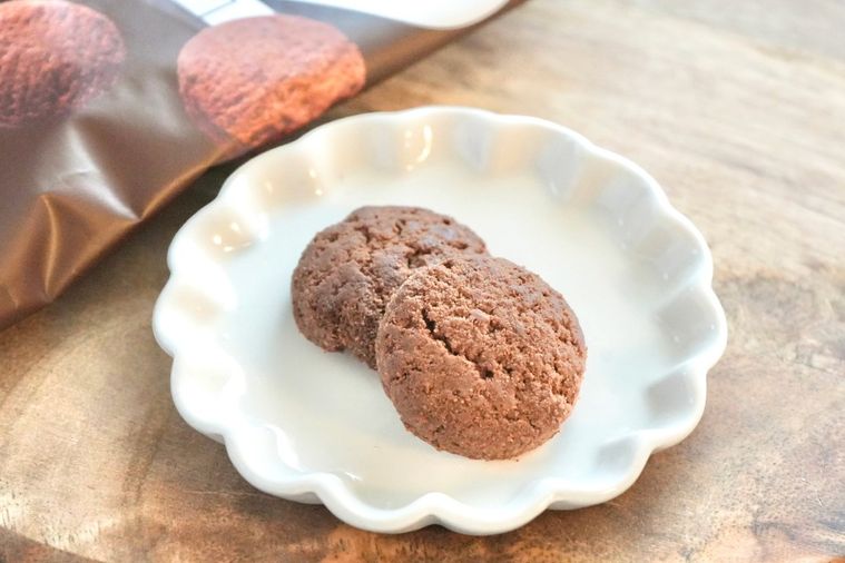 白いテーブルクロスとストライプの布と木のカッティングボードと白い小皿にのったギルトフリーのサブレ