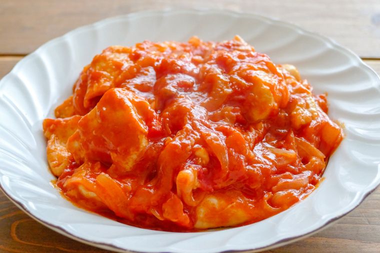 鶏むね肉のトマト煮込みが盛られている白い皿