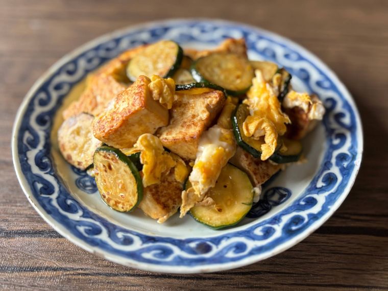 青色の模様の皿に盛られたズッキーニ、豆腐、卵の絶品チャンプルー風