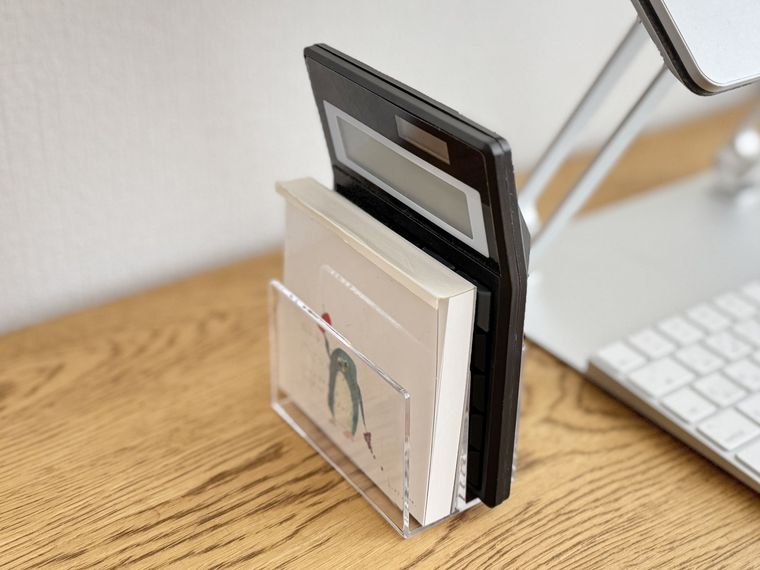 仕切りスタンドにメモ帳や電卓を立てかけた様子