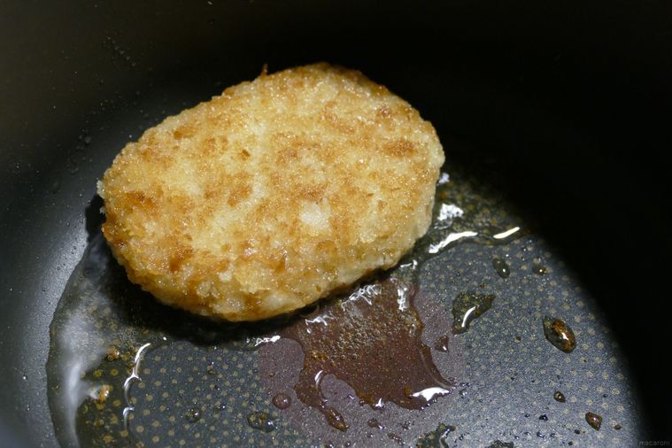 色づいたコロッケを返して少量の油で揚げ焼きにする様子