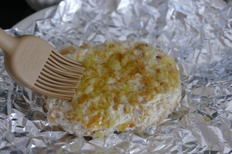 冷凍コロッケの表面に刷毛で油を塗る様子