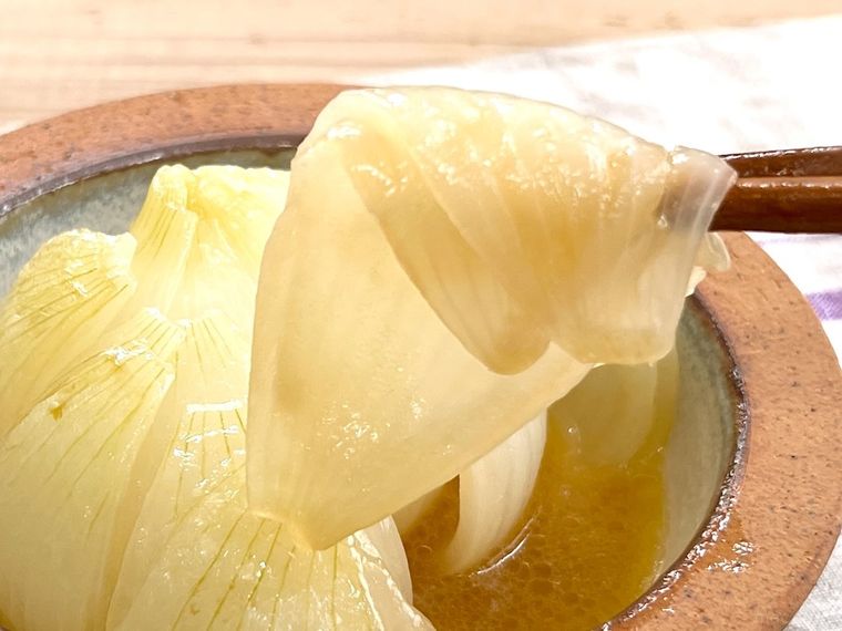 丸ごと新玉ねぎのバタぽんを箸でつまんでいる様子