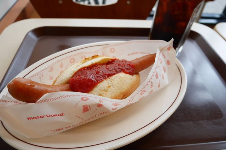 トレーに並ぶミスタードーナツのホットドッグとコーヒー