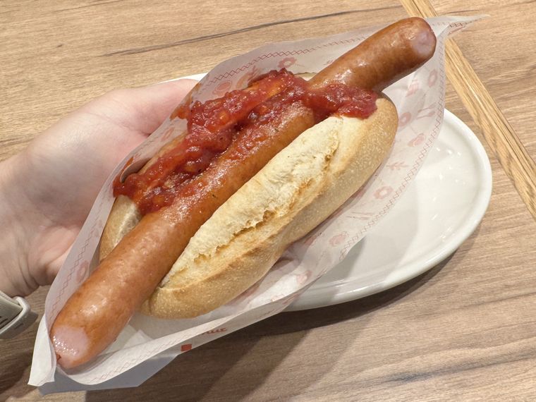 ミスタードーナツのホットドッグを手で持っている様子