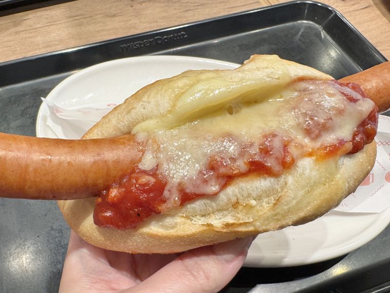 ミスタードーナツのチーズドッグを手で持っている様子