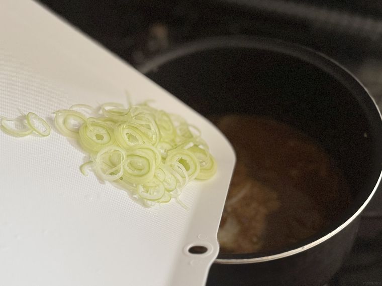 セリアなるほど清潔まな板で鍋に長ねぎを入れようとしている様子