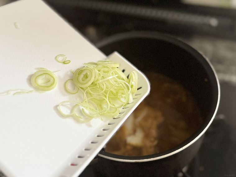セリアちょい切りまな板で鍋に長ねぎを入れようとしている様子