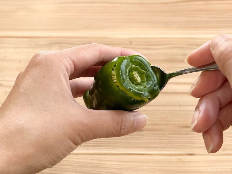 ピーマンの種をスプーンで取っている様子