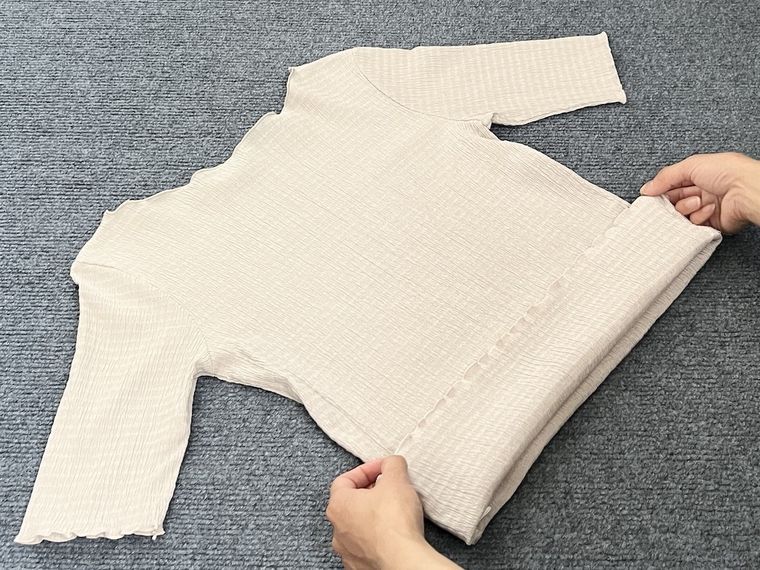 カットソーをたたんでいる様子