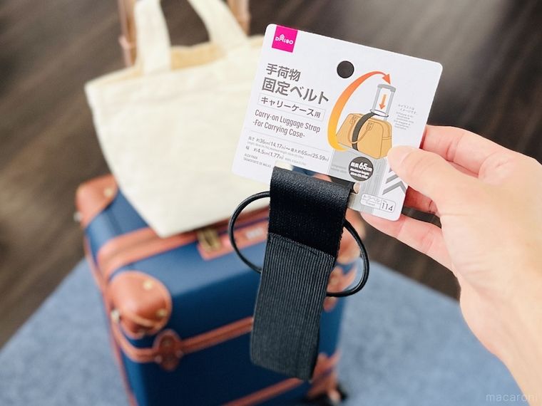 ダイソーの「キャリーケース用 手荷物固定ベルト」を手で持っている様子