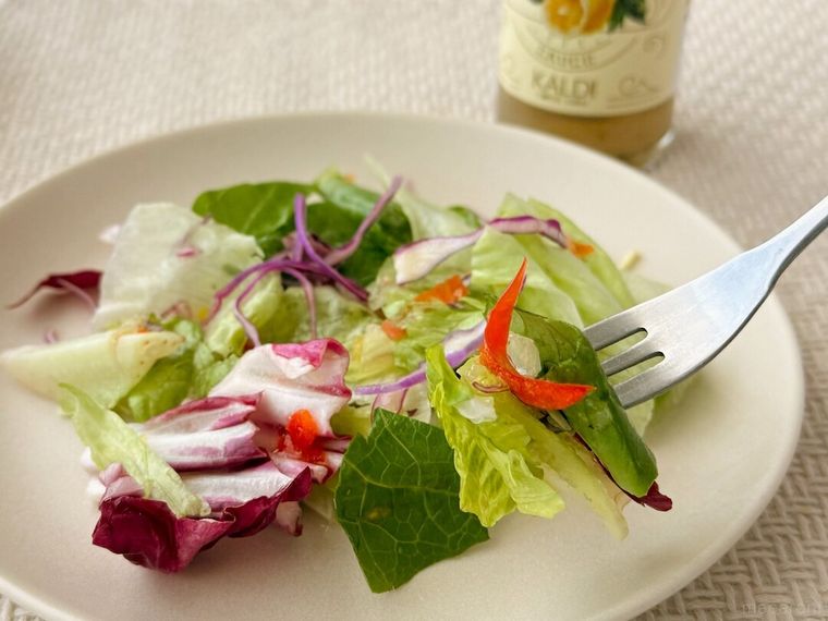 レモントリュフドレッシングソースがかかった野菜を持っている様子