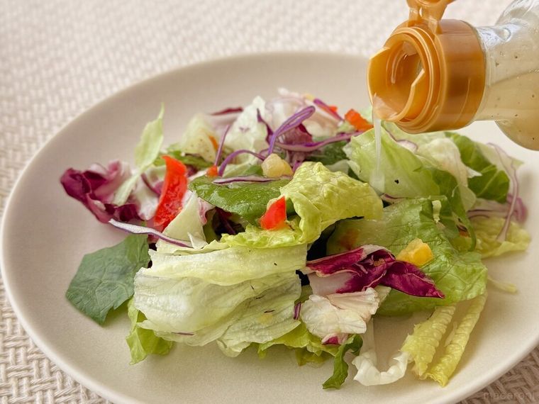 野菜の上にレモントリュフドレッシングソースをかけている様子