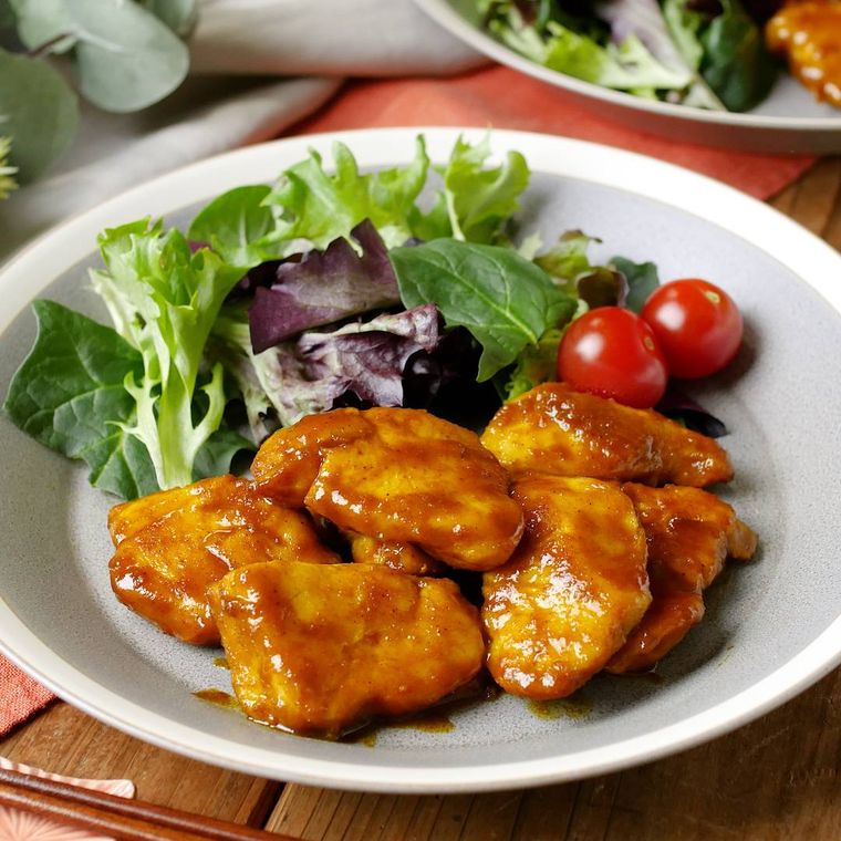 白い皿に盛り付けられた鶏むね肉で作るカレー照り焼き