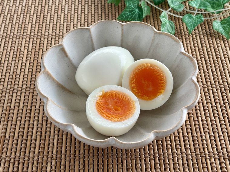 1つのカットしていないゆで卵とカットしたゆで卵の写真