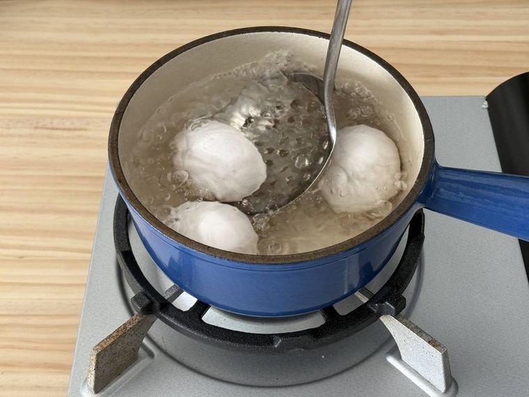 鍋に卵を入れている写真