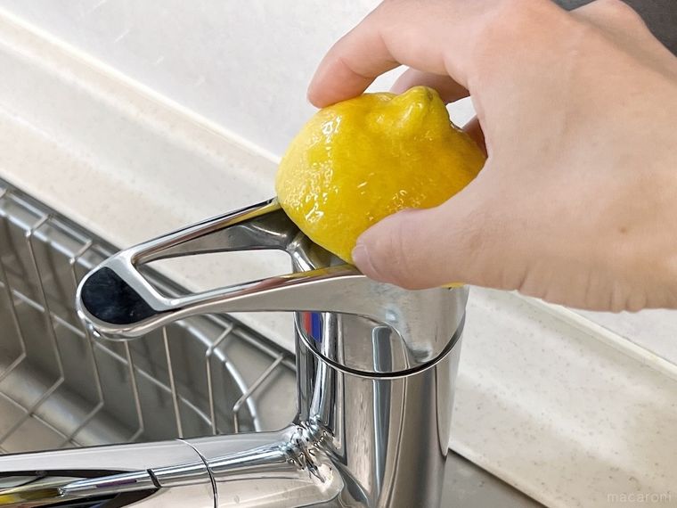 使用済みのレモンで蛇口の水垢をこすっている様子