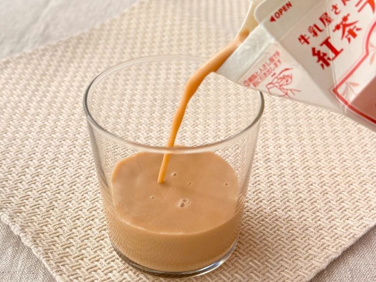 「牛乳屋さんがつくった紅茶ラッテ」をコップに注いでいる様子