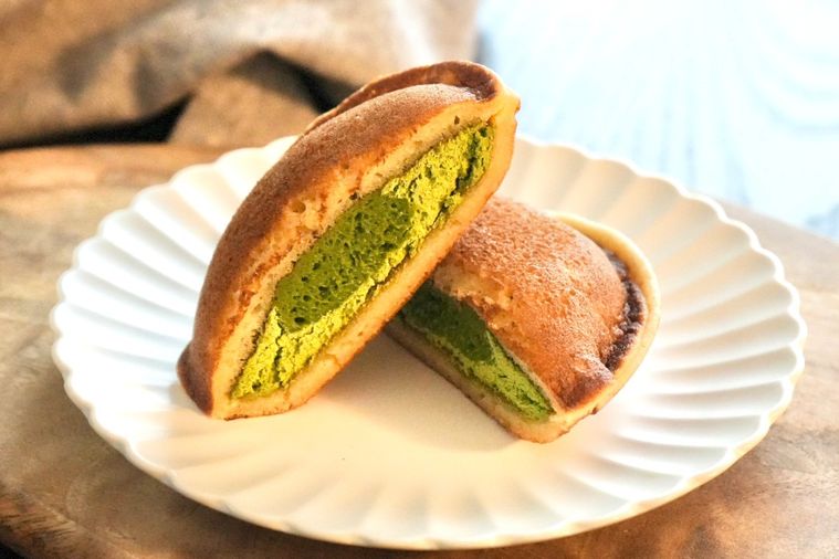 木のカッティングボードと白い皿にのった老舗お茶ブランド森半コラボのどら焼きスイーツの断面とグレーの布