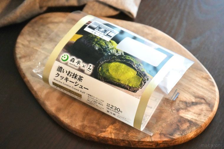 木のカッティングボードにのった老舗抹茶森半コラボのコンビニシュークリームとグレーの布