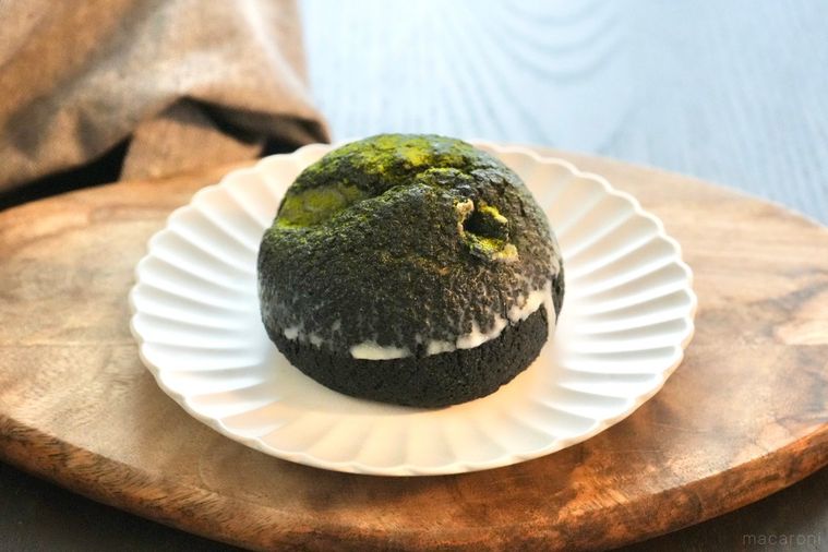 木のカッティングボードと白い皿にのった老舗抹茶森半コラボのコンビニシュークリームとグレーの布