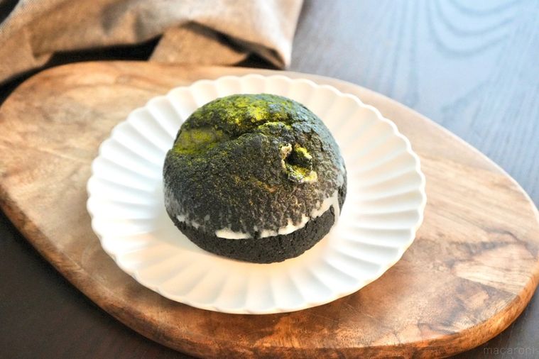 木のカッティングボードと白い皿にのった老舗抹茶森半コラボのコンビニシュークリームとグレーの布