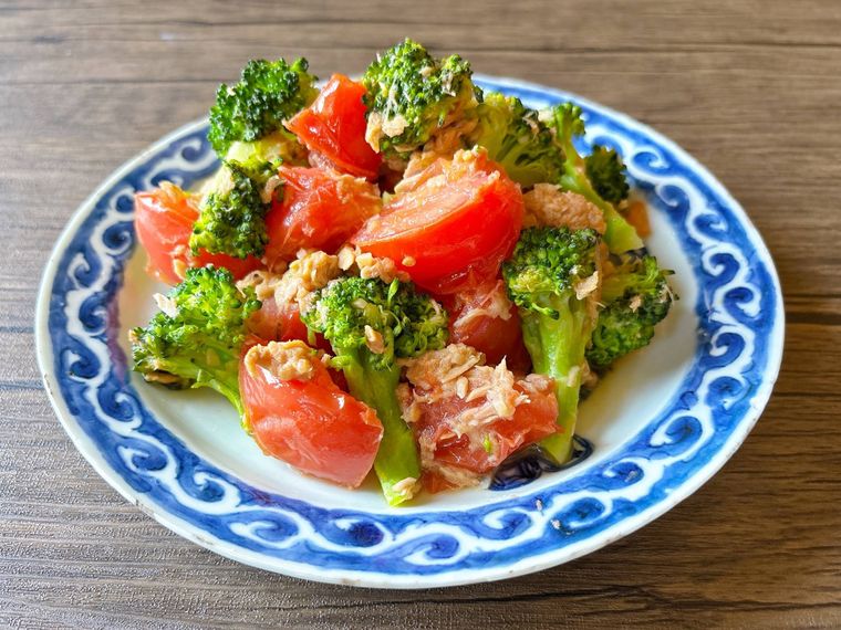 青色の模様の皿に盛られたブロッコリー、トマト、ツナの温サラダ