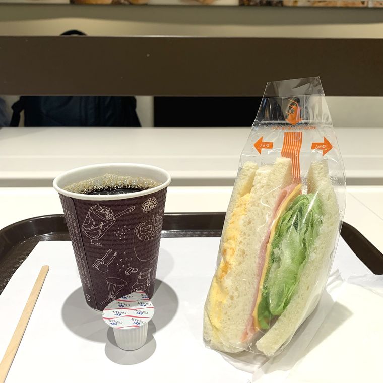 ヴィクトワール 新大阪店のカウンター席に置いたホットコーヒーとミックスサンド