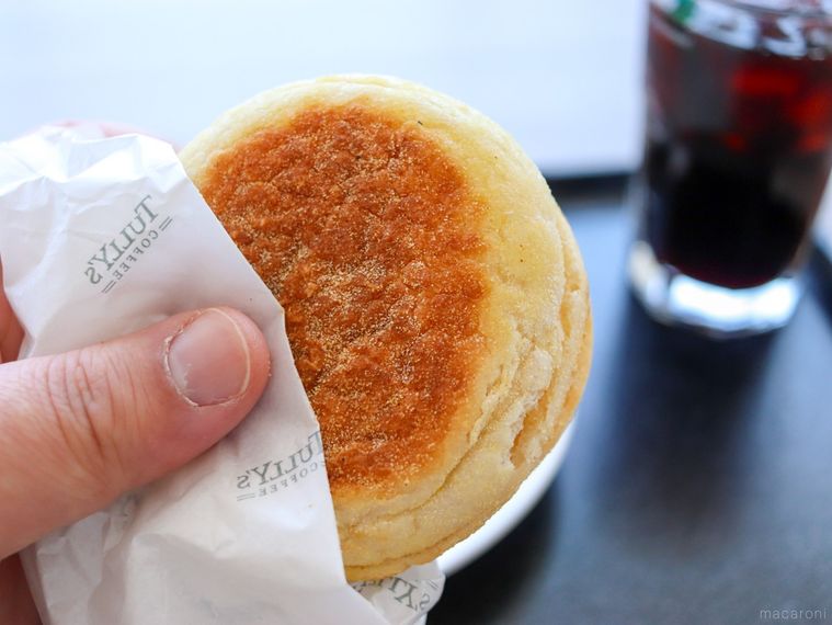 タリーズコーヒーのイングリッシュマフィン ハムエッグを手で持っている