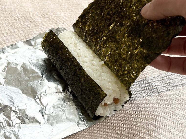 酢飯を海苔で巻いている様子