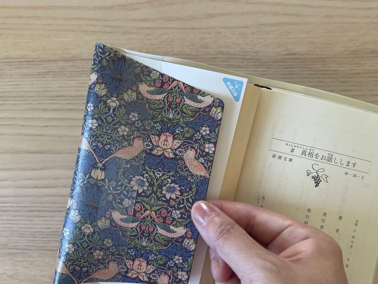 文庫本にセリアのブックカバーを掛けているところ