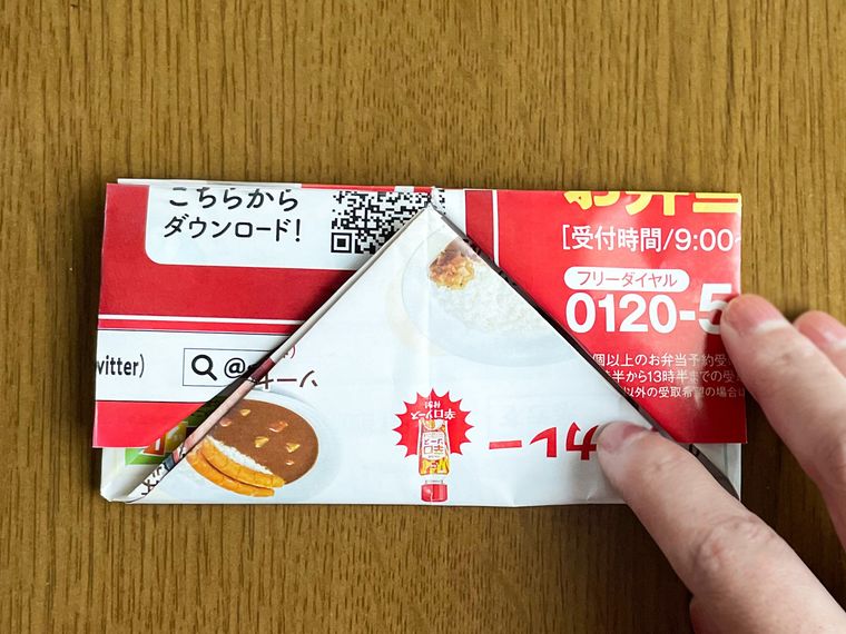 チラシで作ったゴミ箱に折り目をつけている