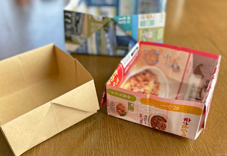 テーブルの上にチラシで作ったゴミ箱を並べた写真