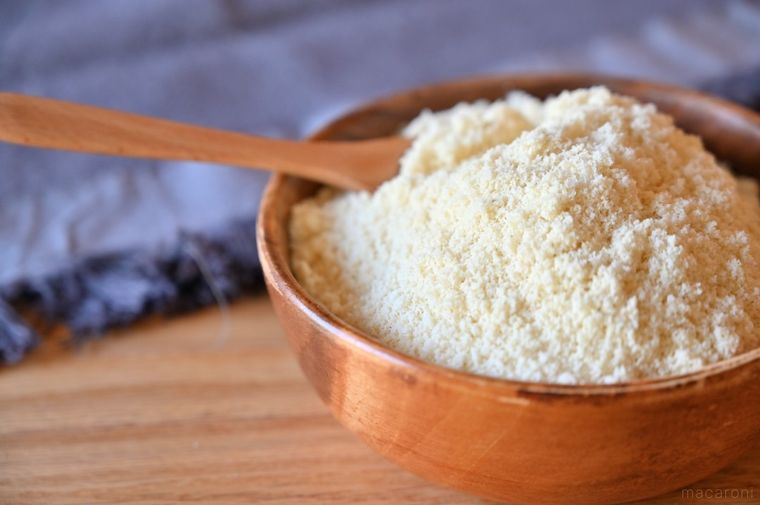 木の器に入ったアーモンドプードルにスプーンを入れている