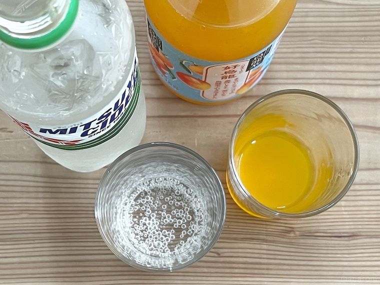 サイダーとジュースをグラスにそそいだ様子