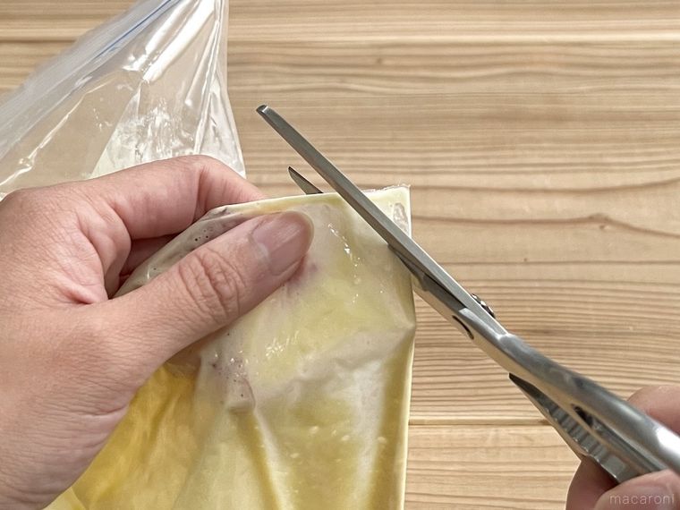 ホットケーキの生地が入ったポリ袋の端を切っている様子