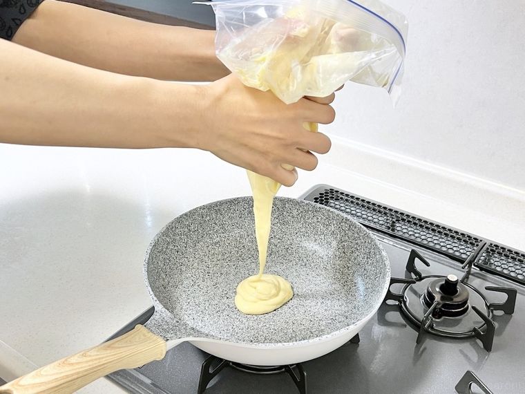 フライパンにホットケーキの生地を絞り出している様子