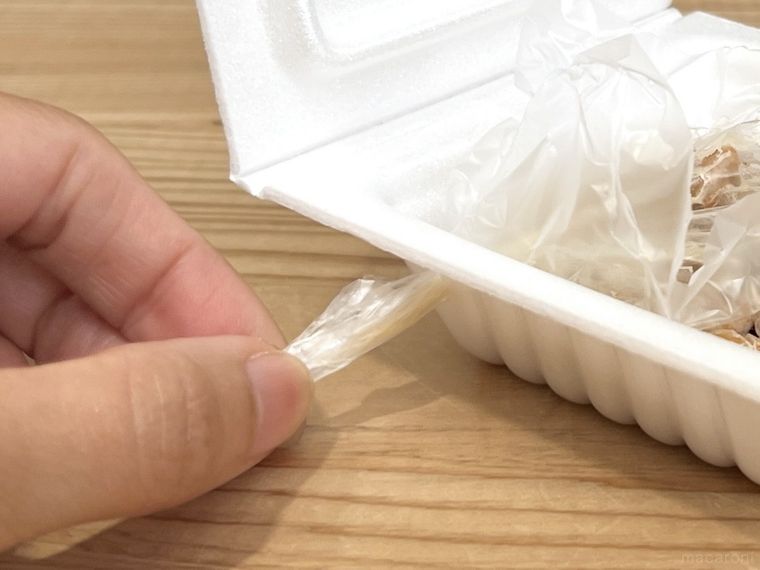 納豆のパックからフィルムを引き抜いている様子